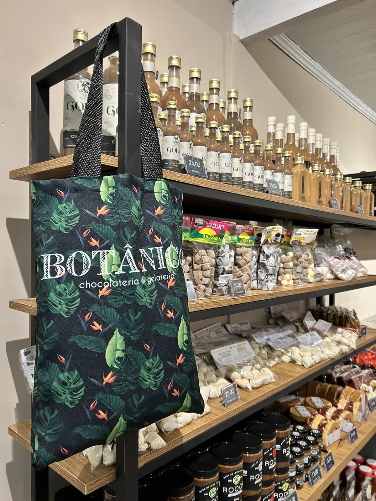 Prateleiras internas com produtos e sacola Botânico