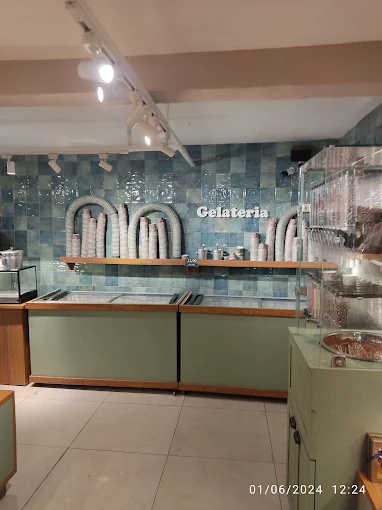 Balcão da gelateria com parede de azulejos azuis